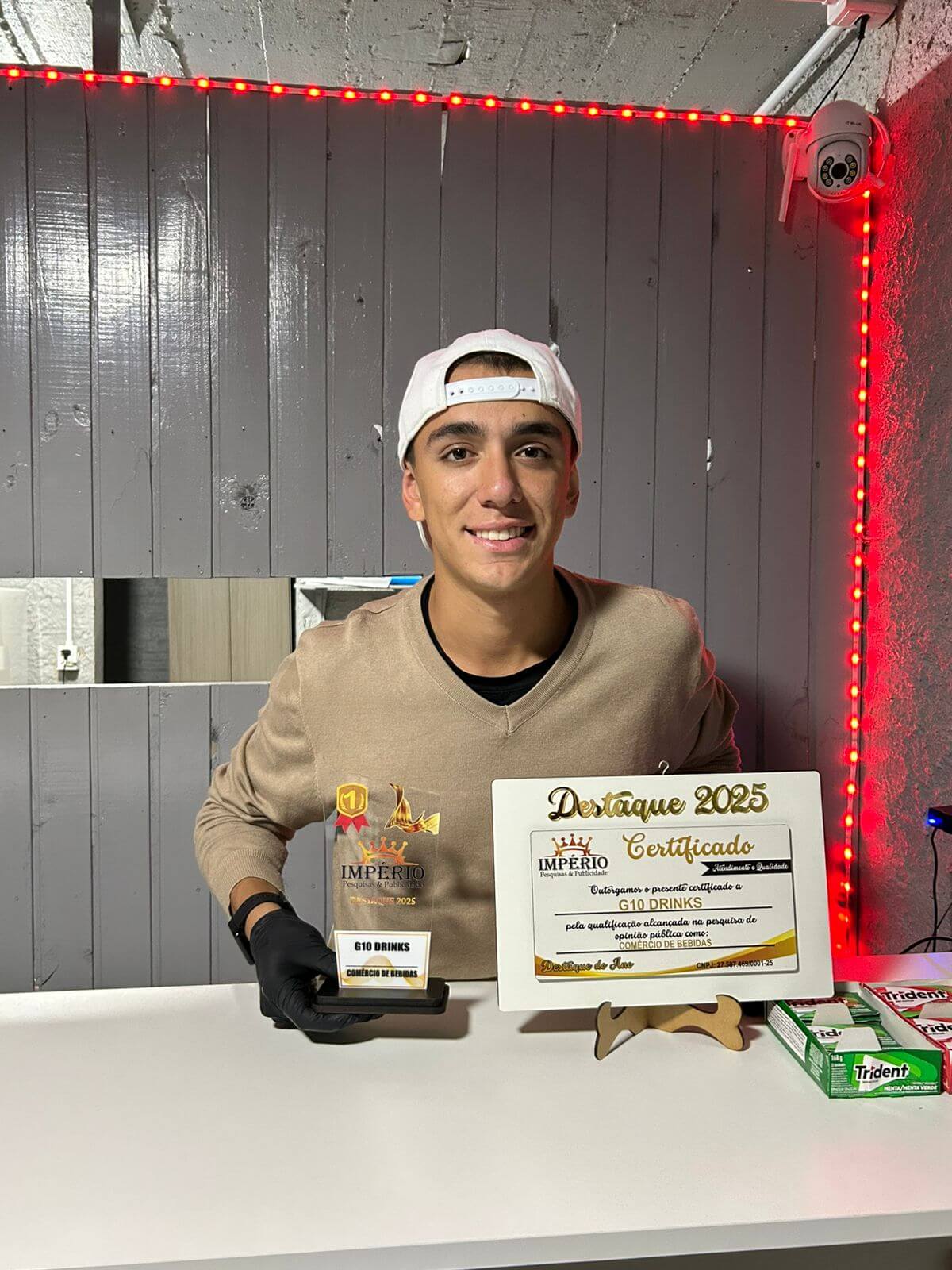 Dono do G10 Drinks segurando o certificado Destaque 2025